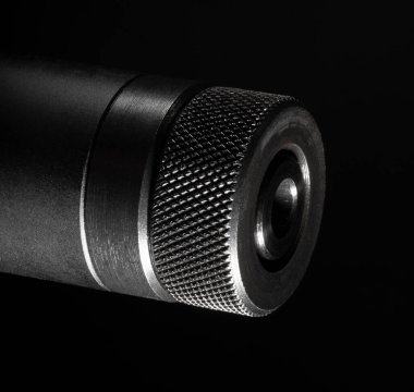 Siyah arka planı olan bir tüfeğin namlusundaki iplik koruyucusu.