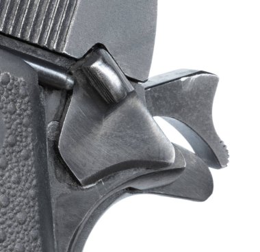 1911 model bir tabancada, beyaz bir arka planda çekiçle korunan emniyetin kapatılması..