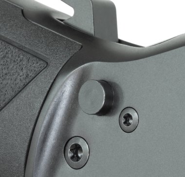 Siyah manevra tüfeğinin güvenlik düğmesinin yakın plan görüntüsü beyaz arka planda izole edilmiş..