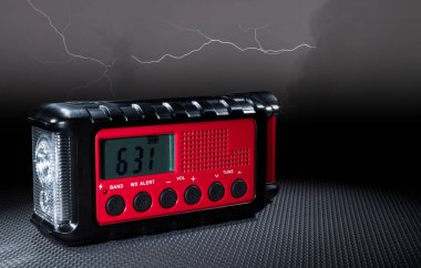 İçinde saat ve el feneri bulunan acil hava durumu radyosunun arkasındaki elektrik fırtınası