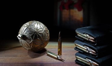 Karanlık bölümde şöminesi açık, Noel çorapları altın bir Noel süslemesinin üstünde asılı ve AR-15 şarjörleri dolu bir masada..