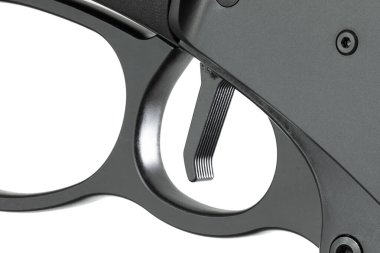 Beyaz arka planda izole edilmiş yakın planda görülen siyah bir manevra tüfeğinin tetiğindeki doku..