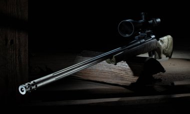 Bir kamuflaj tüfeğinin yüksek güçlü dürbünü ve kirli eski bir binanın karanlık bir noktasından ateş etmek için hazırlanmış flüt namlusu..