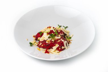 İnce dilimlenmiş pancar carpaccio 'yu sunan gurme aperatifler, üzerine tıraş edilmiş peynir, çıtır badem ve taze lahanalar.