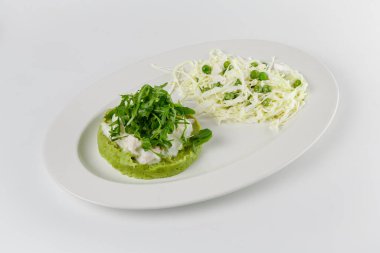 Kremalı sos ve roka soslu taze bezelye püresi tabağı, yanında doğranmış lahana ve bezelye salatası.