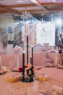 Modern bir çiçekli süslemenin yer aldığı zarif bir yemek masası ya da düğün resepsiyonu için hazır.