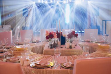 Mumlar, çiçekler ve ışıl ışıl ışıklarla dolu bir sofra özel bir akşam yemeği partisi için şık bir ortam yaratıyor.