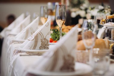 Bayram ya da düğün resepsiyonu için hazırlanmış şenlik masası. Süslü peçeteler ve aperatiflerle şampanya bardağı ve ekmek.