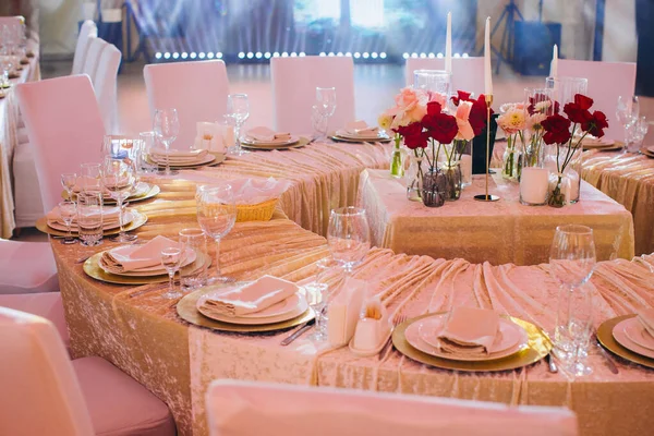 Dekore edilmiş resepsiyon masası titizlikle düzenlenmiş yer ayarları, çiçekli süsler, sofistike bir atmosfer yaratıyor.