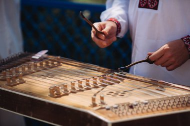 Müzisyen elleri çekiçle dövülmüş geleneksel bir semimcinin tellerine vuruyor. Bir telli çalgıyla halk müziği çalıyordu.