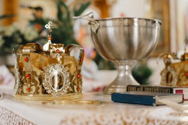 İkonografili altın taç ve sunakta gümüş vaftiz kasesi, Hıristiyan Ortodoks dini ayinine hazır.