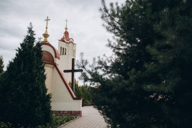 Bulutlu gökyüzüne karşı birden fazla haçın ve yemyeşil ağaçların bulunduğu kilise mimarisi inanç ve maneviyatı simgeliyor.