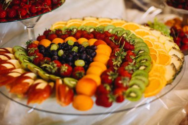 Tabakta taze meyve çeşitleri, sağlıklı atıştırmalıklar ve ferahlatıcı yiyecekler sunuyor.