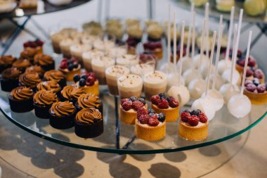 Kutlama etkinliği için çeşitli lezzetli mini kekler, meyveli turtalar, köpüklü bardaklar ve kekler sergilenecek.