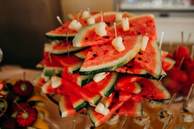 Kırmızı karpuz dilimleri, küçük meyve parçaları ve kürdan. Bir catering etkinliğinde taze tatlı gösterisi için.