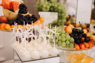 Zarif bir tatlı ve yiyecek servisi. Kutlama için çeşitli sağlıklı meyveler ve yaylı tatlı kek çubukları.