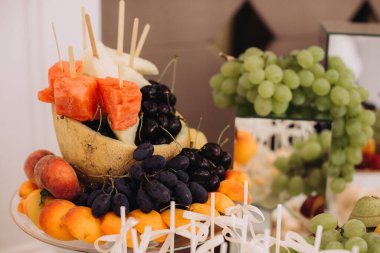 Bir etkinlikte renkli ve sağlıklı bir karpuz, üzüm, kavun, şeftali ve kayısı seçimi sunan taze meyve tabağı