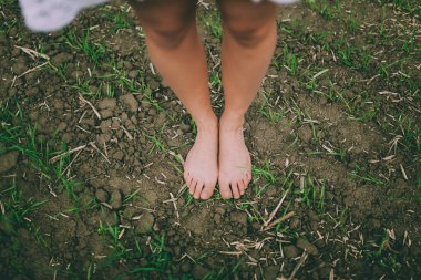 Çıplak bacaklar ve ayaklar verimli topraklara bağlanıyor, doğal yaşam, büyüme ve toprak bağlantısını geliştiriyor.