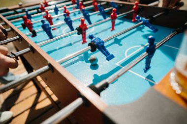 Futbol sahasında sıradan bir langırt, mavi ve kırmızı oyuncular oynarken elleri sıkıca kavrıyor