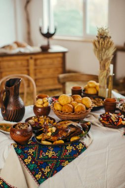 Kızarmış ördek, pampushky ve diğer geleneksel Ukrayna yemeklerini işlemeli bir masada servis etmek kültürel kutlamayı yansıtıyor.