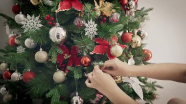 Bu iç açıcı video, bir Noel ağacını ışıltılı ışıklar, renkli süsler ve şenlikli süslemelerle donatmanın neşeli sürecini yakalıyor..