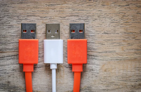 Orange och vit USB-kabel på trä bakgrund. — Stockfoto