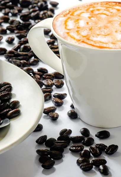 Tasse blanche de café avec grains de café sur fond blanc . — Photo