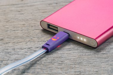 Ahşap arka plan üzerinde kırmızı güç banka.