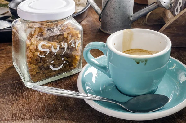 Sale tasse de café et bouteille de sucre sur une table en bois . — Photo