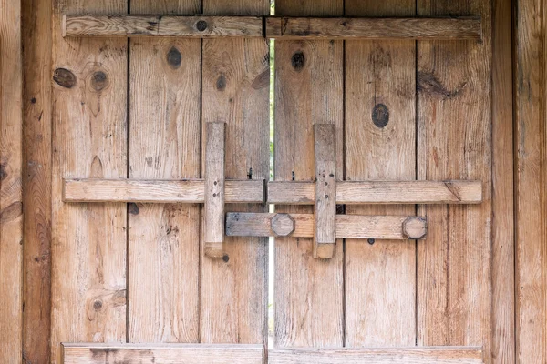 Vintage wooden door with locking bar — Stock Photo, Image