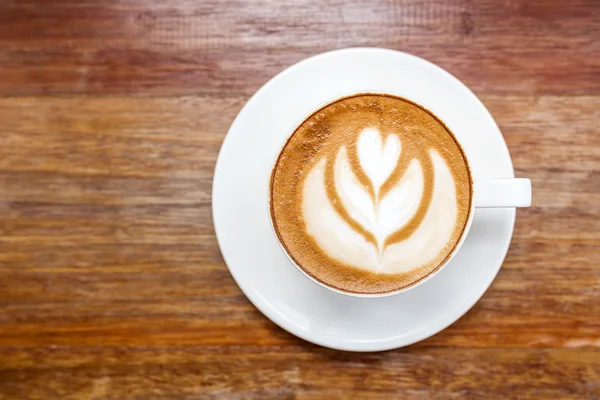 Tasse de café chaud latte art sur table en bois — Photo