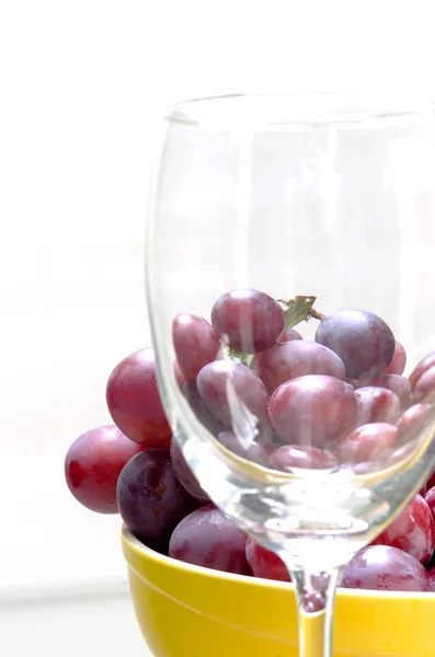 Uvas vermelhas e copo de vinho — Fotografia de Stock