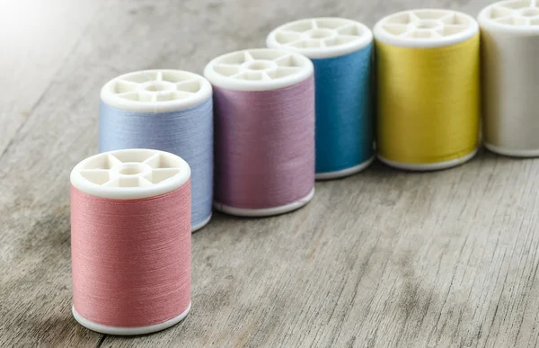 Row of bobbins with thread — Stock Photo, Image