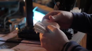 Yaşlı alkolik adamın para saydığı yakın plan.