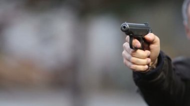 Siyah arka planda yakın plan silahlı bir katil.