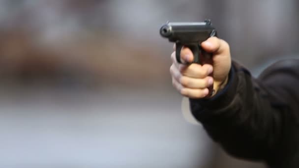 Asesino con pistola de cerca sobre fondo oscuro — Vídeos de Stock