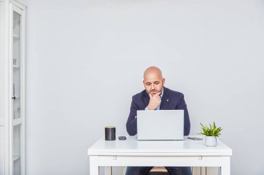 Evde dizüstü bilgisayarla çalışan serbest meslek sahibi bir girişimci. Yetişkin kel adam.