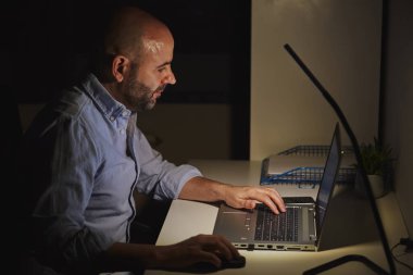 Evde dizüstü bilgisayarla çalışan serbest meslek sahibi bir girişimci. Yetişkin kel adam.