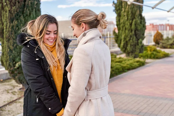 Happy and positive moments of two elegant girls walking down the street in the city. Portrait of young girls having fun, smiling, charming moments, best friend. Concept of friendship and love