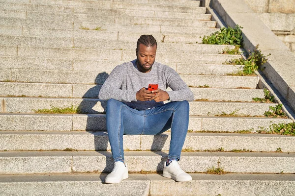 Pria Afrika-Amerika yang duduk di tangga melihat media sosial di ponselnya. Prihatin anak muda. — Stok Foto