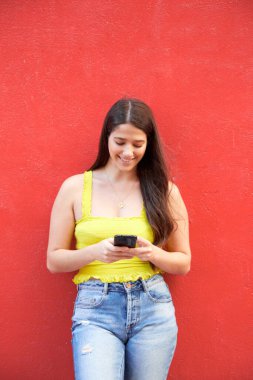Latin Amerikalı nüfuzlu kişi, yazın açık havada fotokopi alanı olarak duvarlı cep telefonuyla çevrimiçi mesaj gönderiyor.