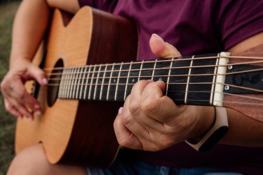 Gitar çalan, gitar öğrenen bir kız.