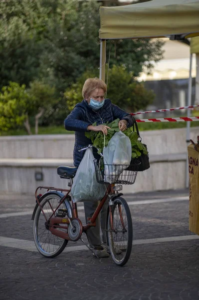 Γυναίκα που κρατάει τσάντες για ψώνια ενώ τις κερώνει με ποδήλατο — Φωτογραφία Αρχείου