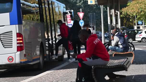 Ludzie wsiadający do autobusu miejskiego na stacji — Wideo stockowe