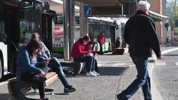 Pessoas sentadas na estação à espera do autocarro — Vídeo de Stock