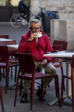 Terni, İtalya Kasım 06 2020: Masada oturan adam bir dilim pizza yiyor.