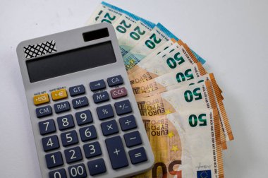 Beyaz arkaplanda hesap makinesi olan 50 ve 20 euro banknotlar