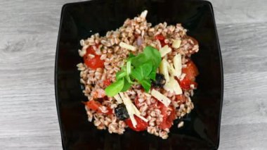 Tahta masada, siyah tabakta sunulan büyülenmiş salata.