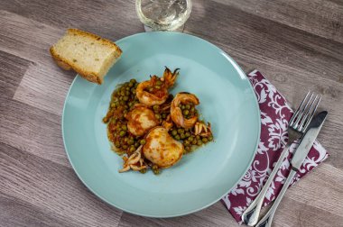 Düz kompozisyon mürekkep balığı ve bir bardak şarap ve ekmek ile bezelye.