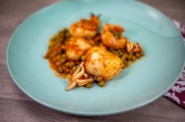 İkinci tabakta mürekkep balığı ve bezelye.